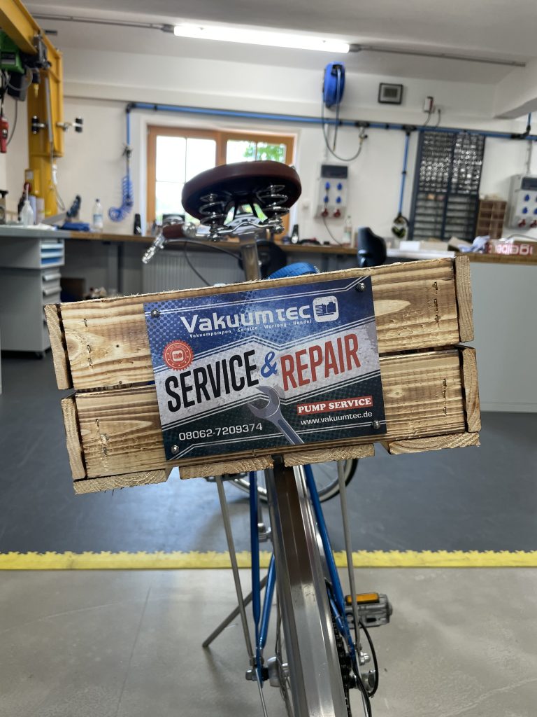 Schild "Service & Repair", im Retro-Look, angebracht an einer Holzkiste auf einem Fahrradgepäckträger.